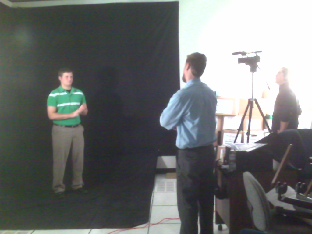 two men in front of blackboard and a man on the phone