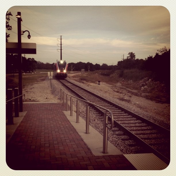 a train on a train track next to a brick walkway