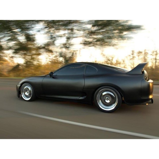 this black sports car is speeding down the road