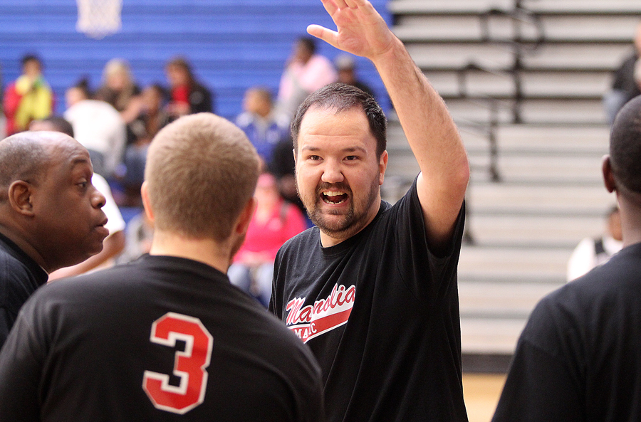 a man wearing a t - shirt raising his hand to the camera