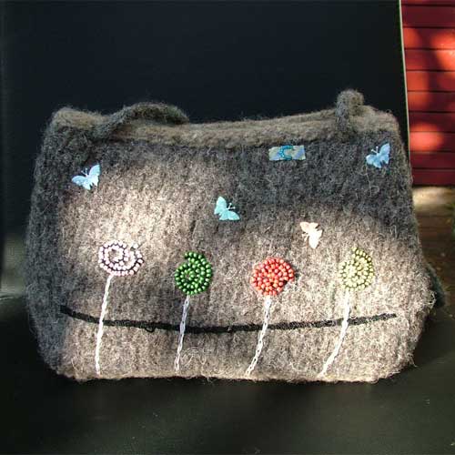 the bag is made out of felt and has flowers on it