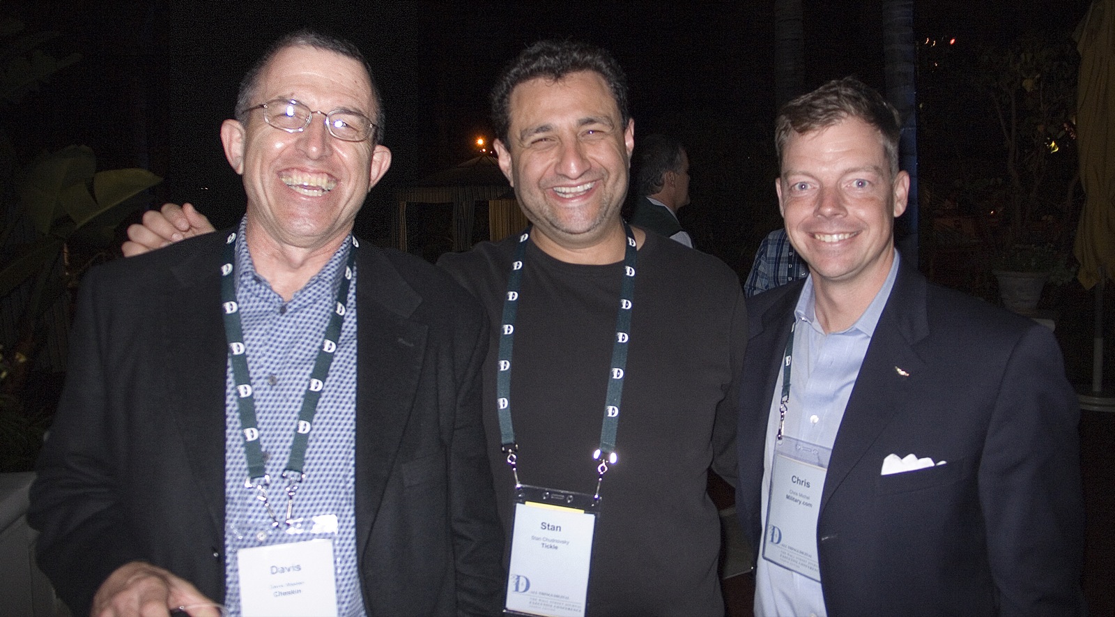 three men smiling for the camera at an event