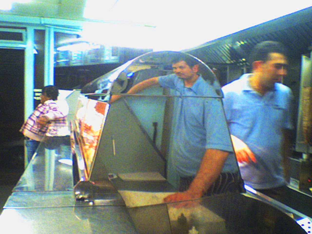 men walk down a long narrow metal conveyor belt