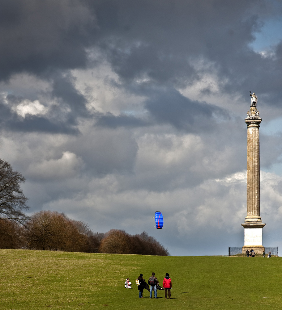 people in red shirts are standing by the monument