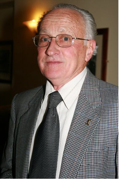 an older man wearing glasses and a jacket