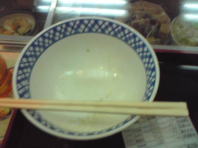 some chop sticks and a bowl with food in it