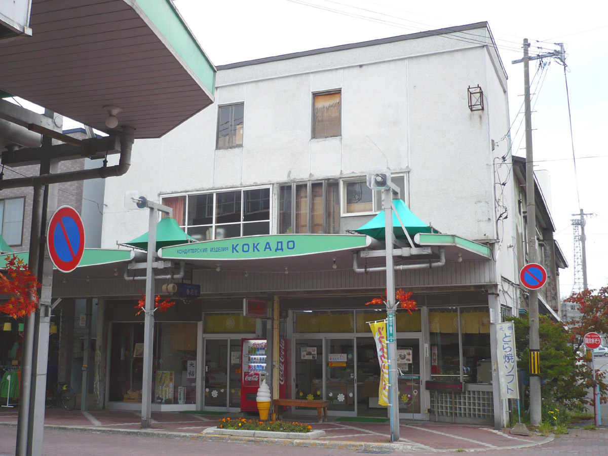 an empty business building that has green umbrellas in front