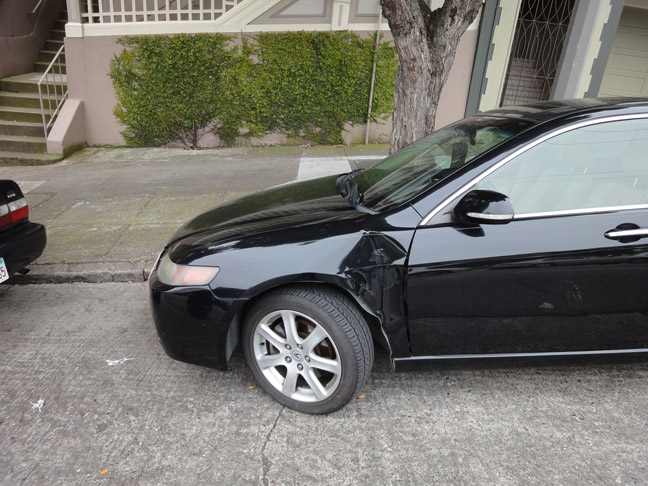 a black car that has been damaged on the street
