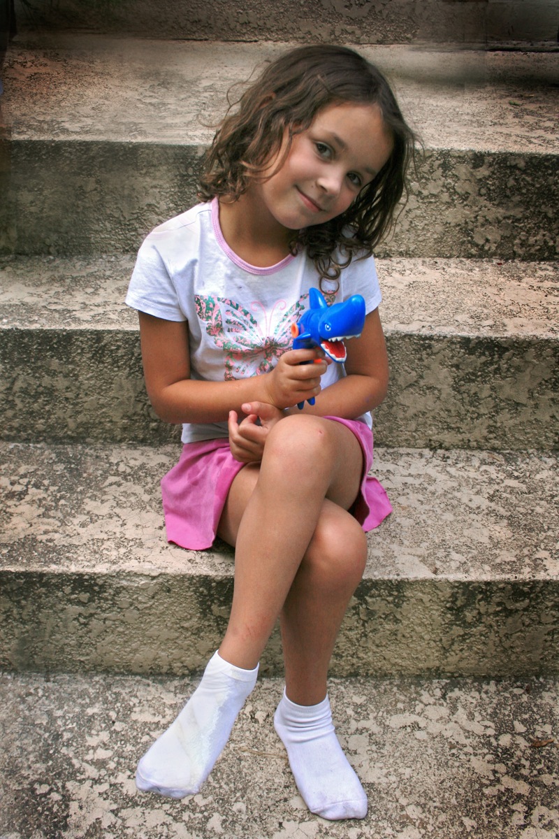 a little girl is sitting on the stairs