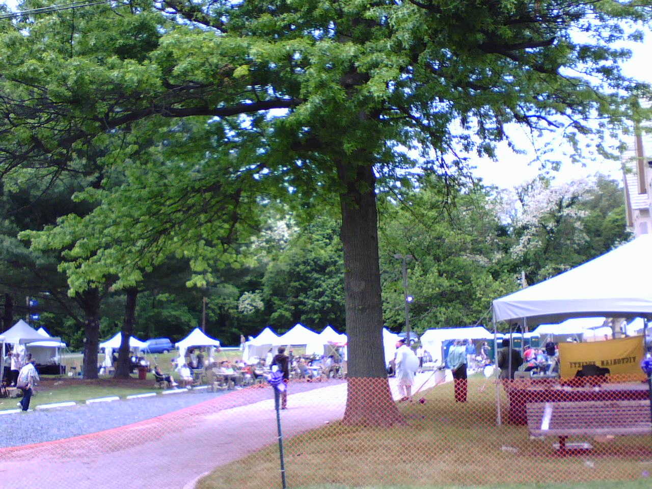 a man stands near a group of tables at a farmers market