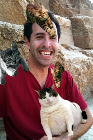 a man standing with two cats on his shoulder