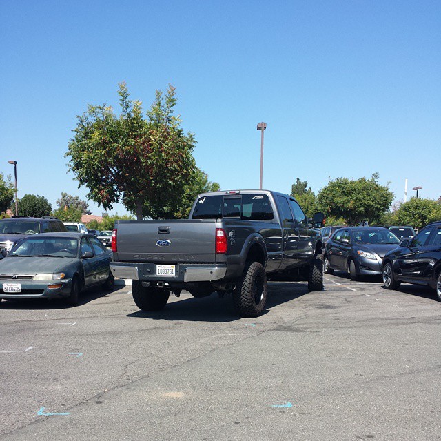 a black pickup truck parked in a parking lot next to another black truck