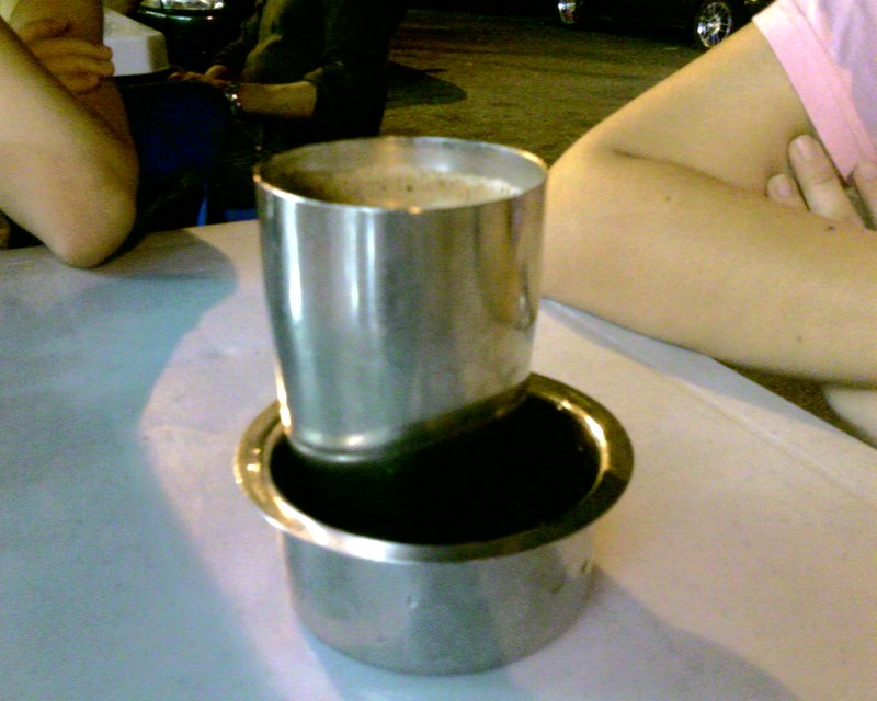 a metal cup with the bottom raised sits on a white table