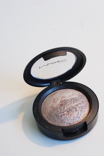 this is a compact powder eye shadow in a black and silver tin