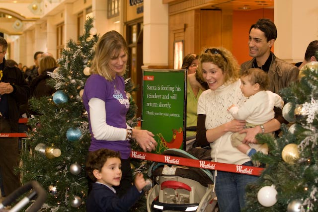 a mother and father with their son and daughter on christmas morning