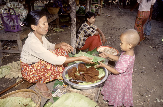 a woman is serving her child rice from a large pan