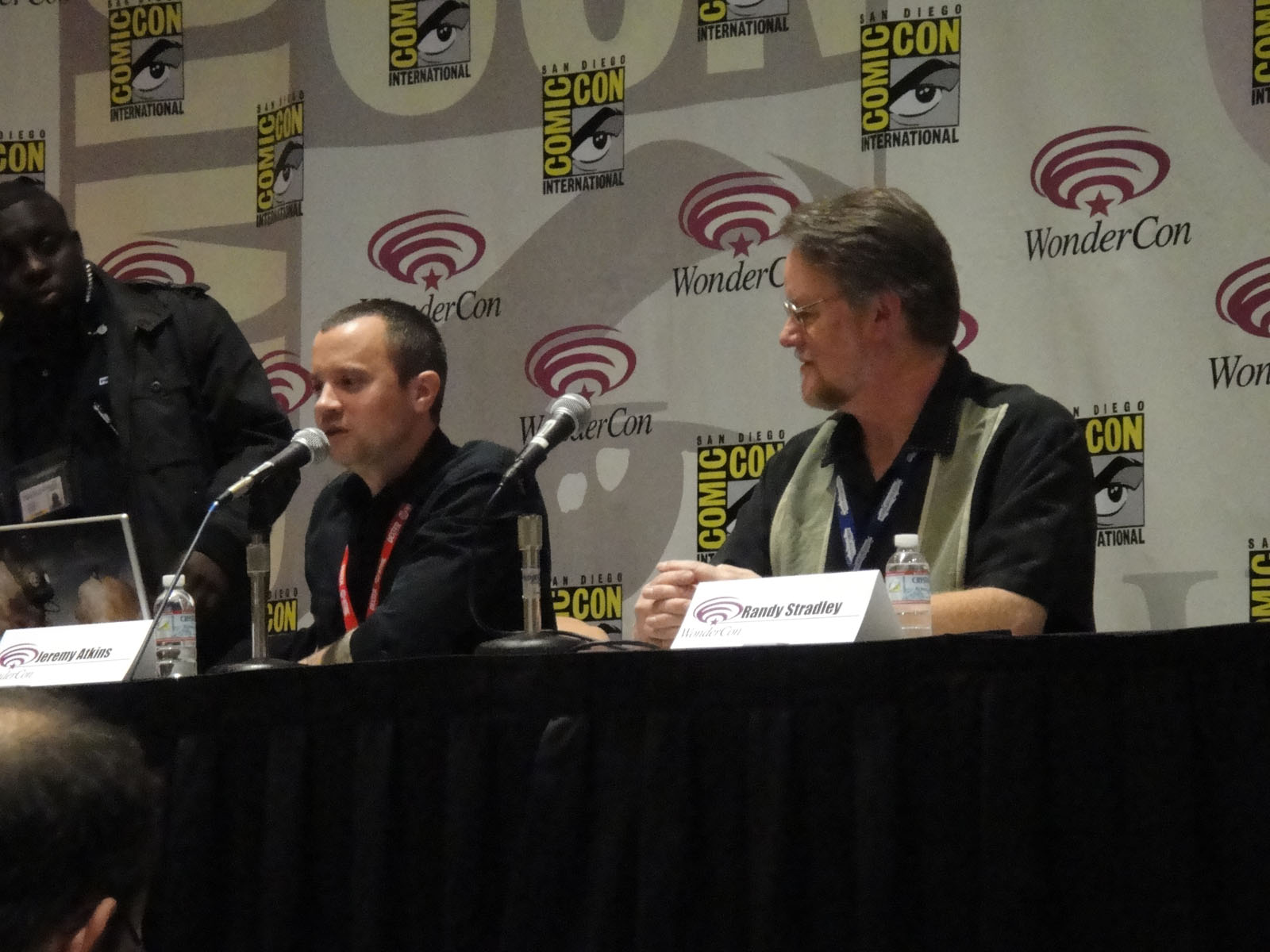 a number of people at a convention on stage with microphone