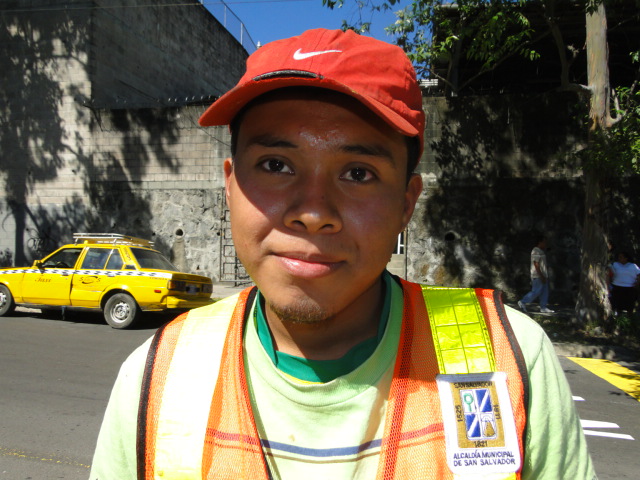 a person standing in the street wearing safety clothing and orange vest