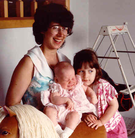 the woman is posing with two little girls
