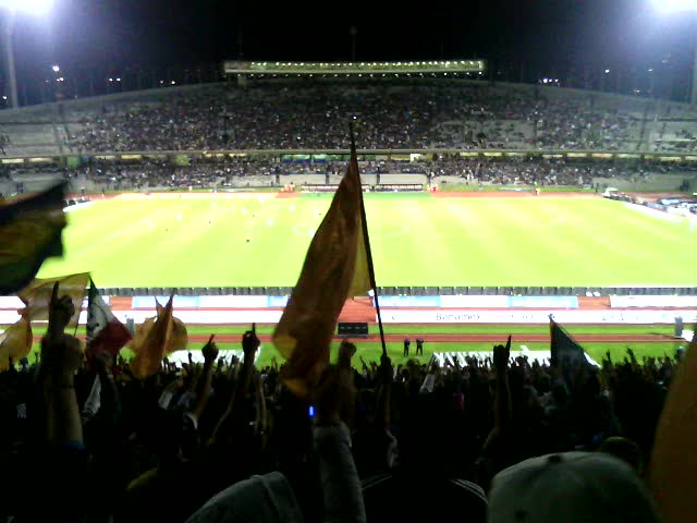 an empty stadium with fans and flags