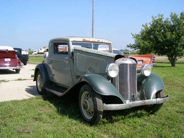 an old fashioned car on display in a field