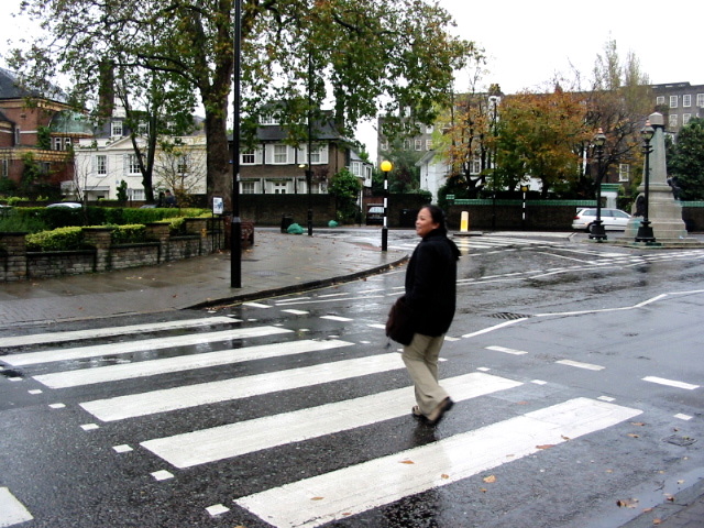 a man walking down the middle of a wet road