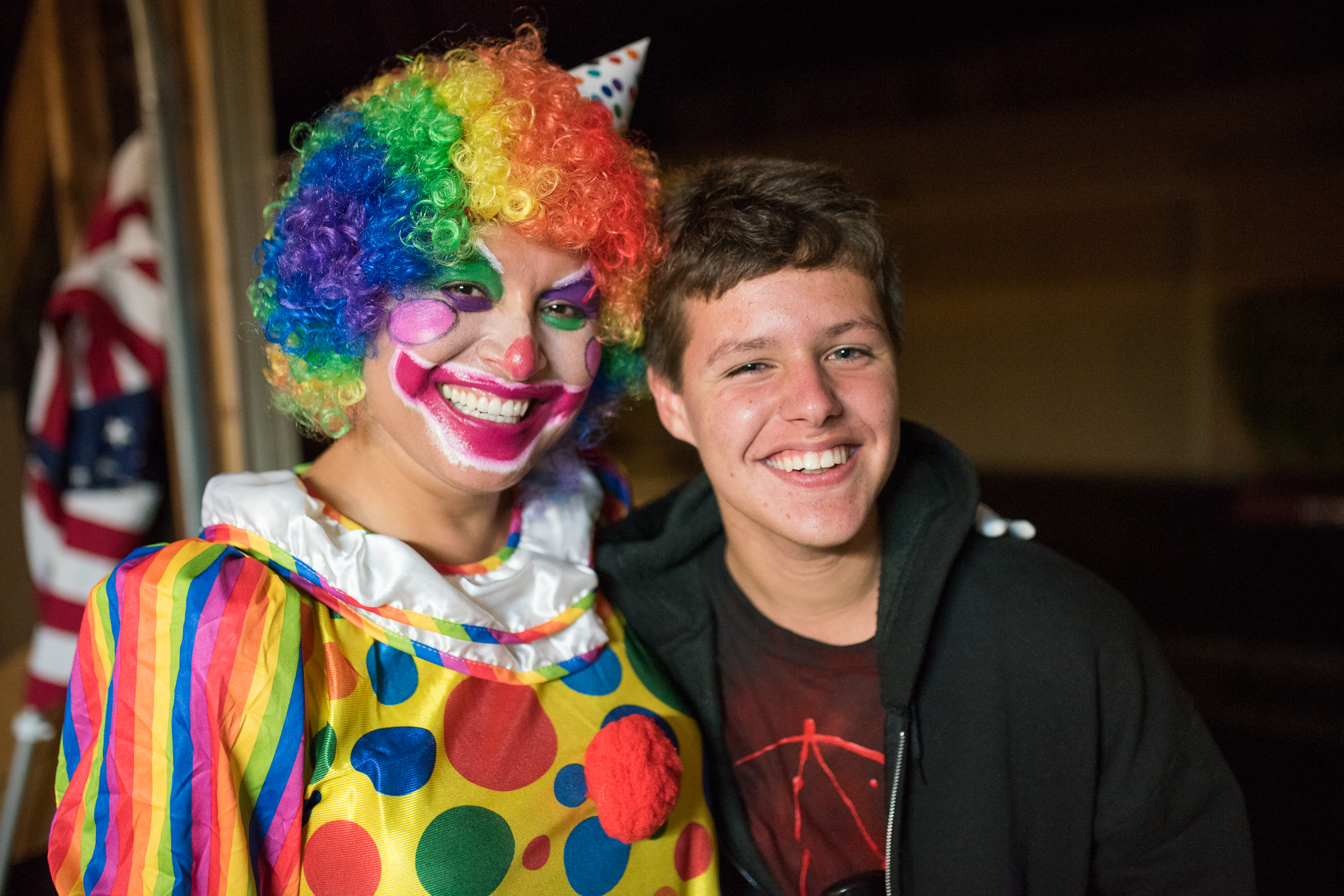 two boys with clown makeup are smiling together