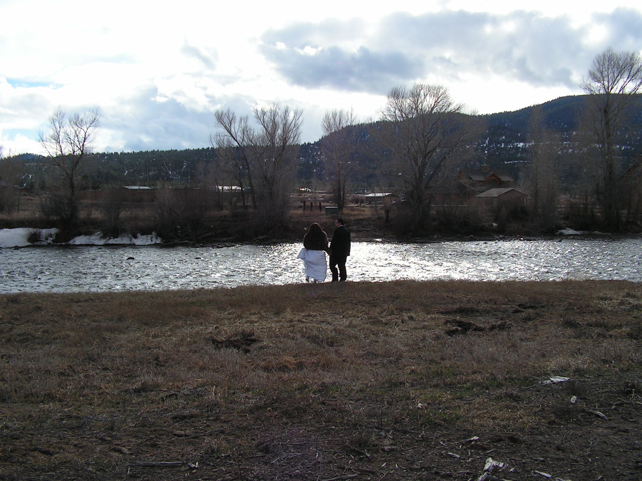 a couple is flying a kite in front of the water