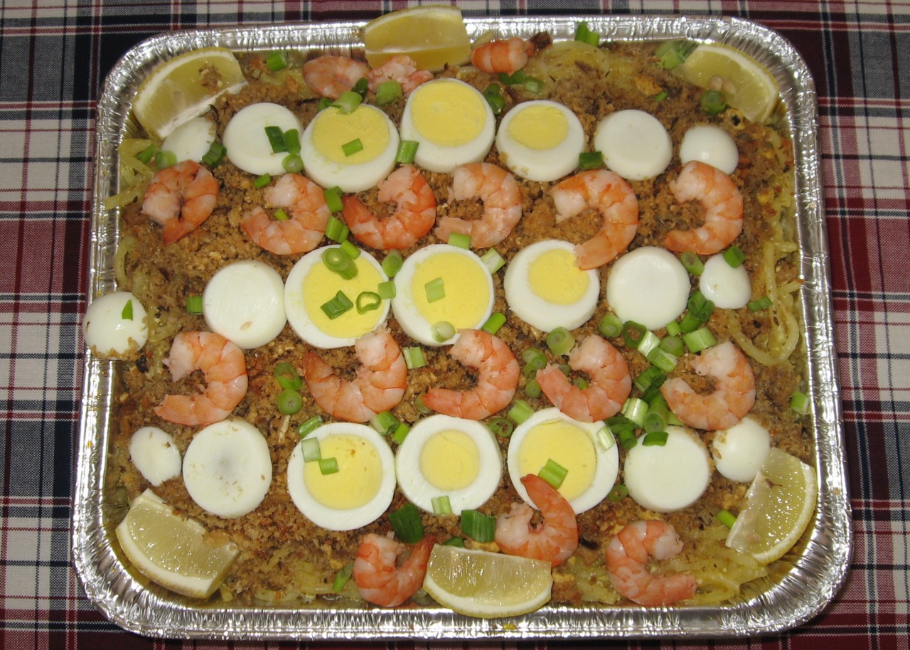 an entree dish with lemon slices, shrimp, and hard boiled eggs