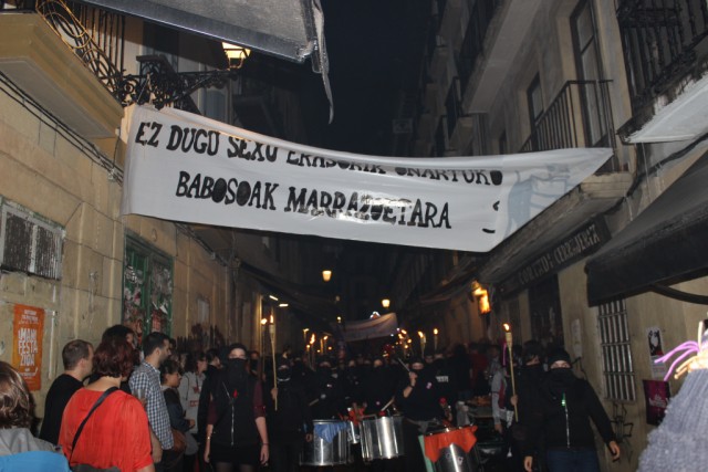 a banner at an outdoor market with people walking around