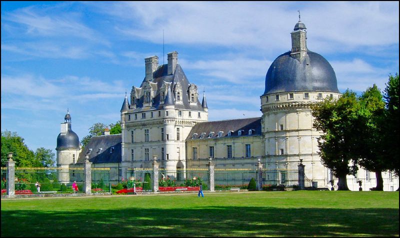 a large castle with many towers sits near a forest