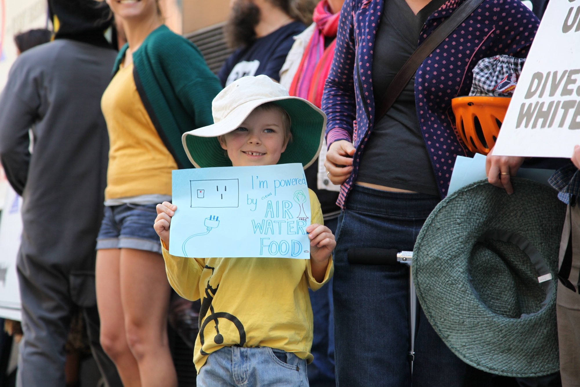 a young child is holding a sign and wearing a cowboy hat
