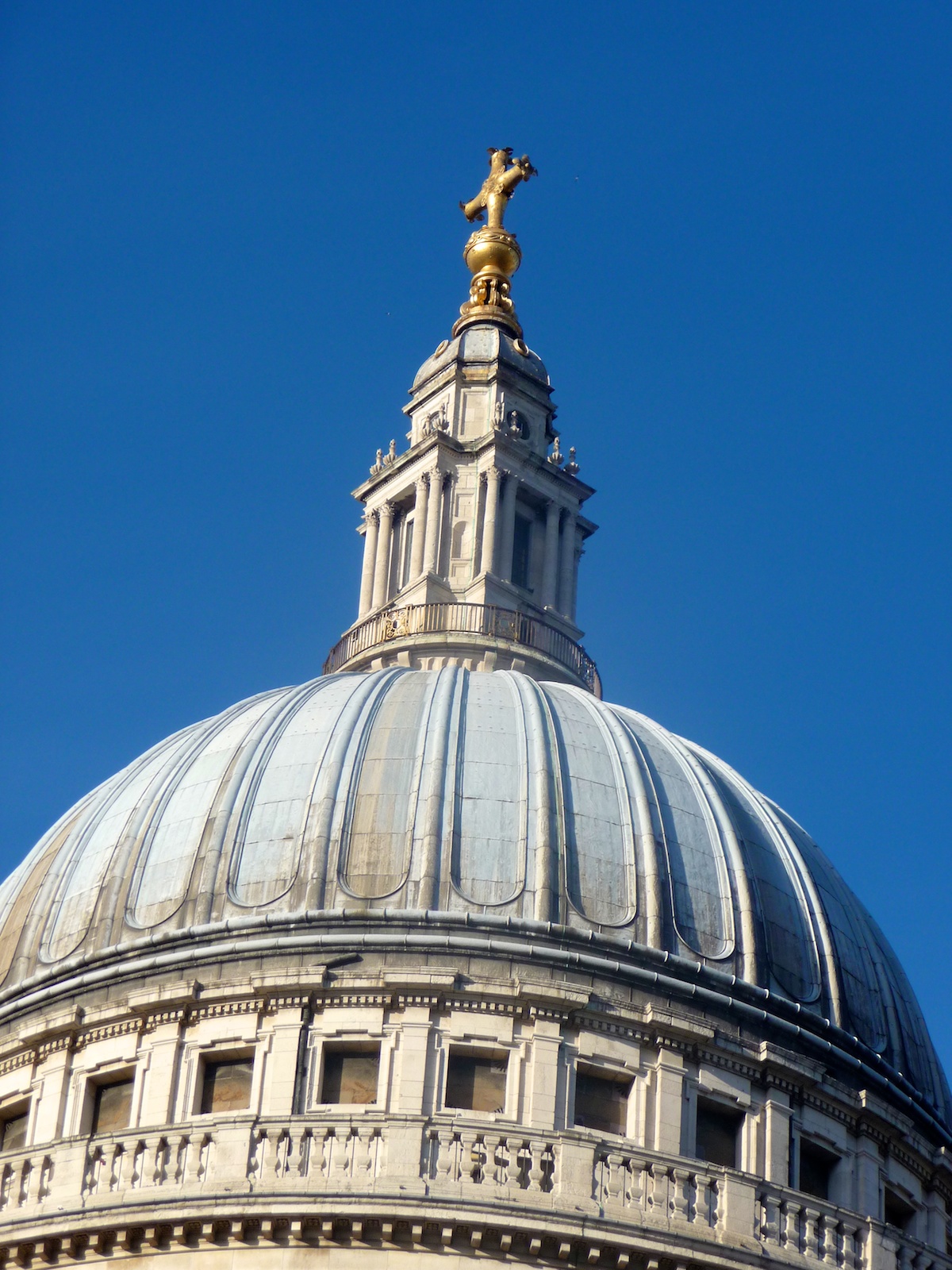 a dome with a cross on top in front of a blue sky