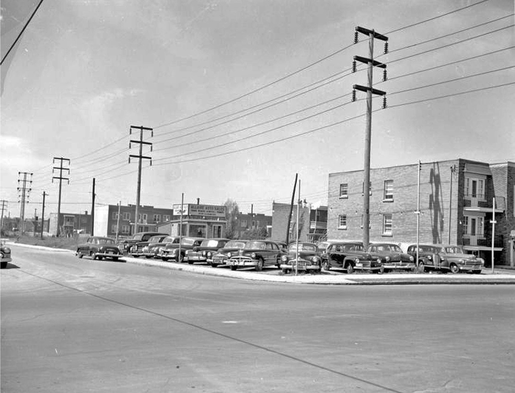 an old time picture of some cars parked in a parking lot