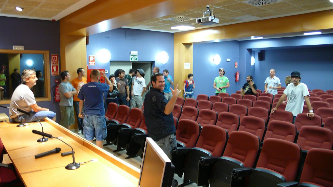 a large group of people standing around a lecture hall