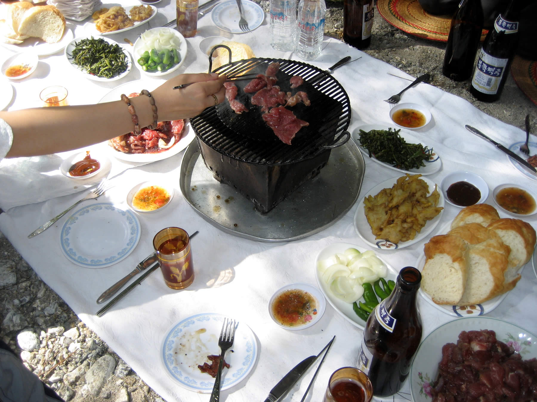 a table with a grill and several plates of food on it