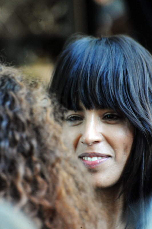 woman with bangs and blue hair talking to someone