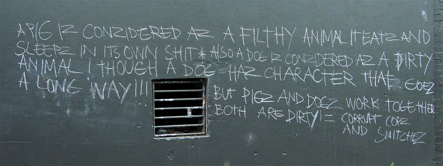 graffiti on the side of a grey building near a window