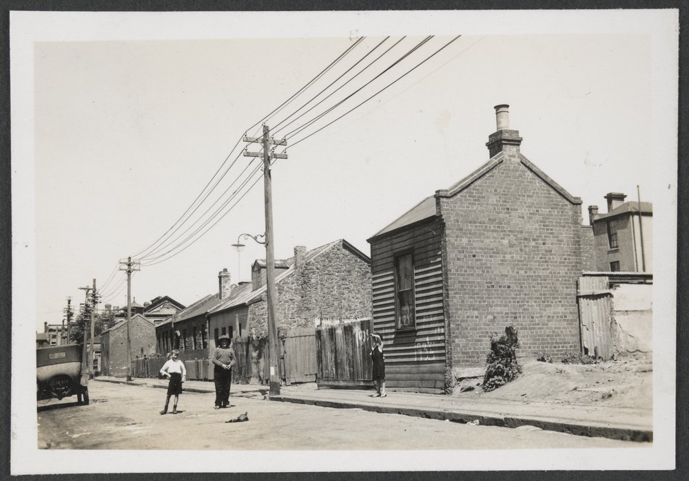 an old black and white po shows people walking on a street