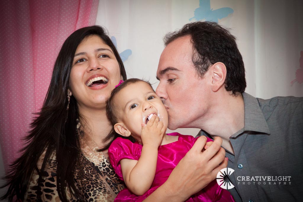 a man, woman and child smile and kiss each other