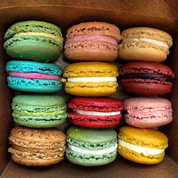 a cardboard box full of assorted colored macaroons