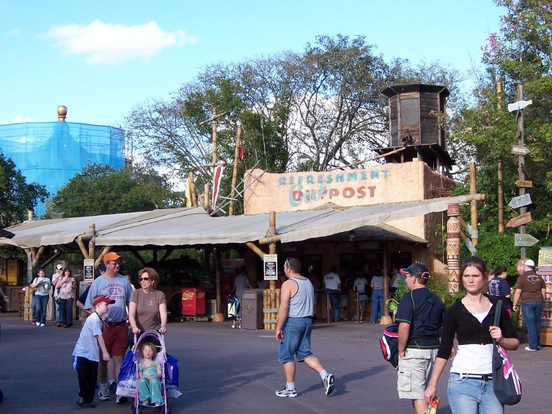 several people walking outside a fair in the sun