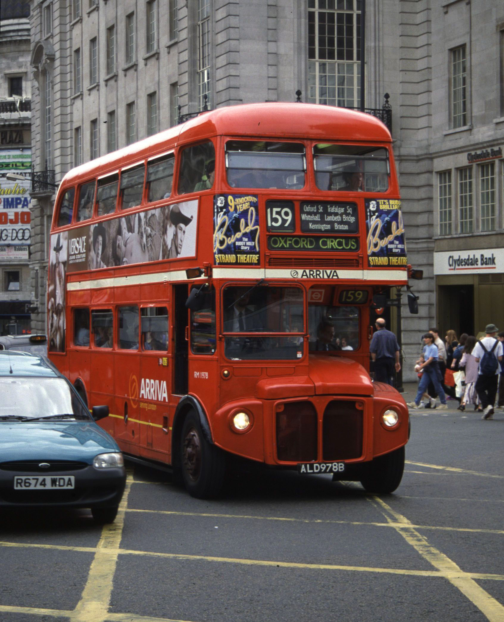 a double decker bus drives through a busy city area