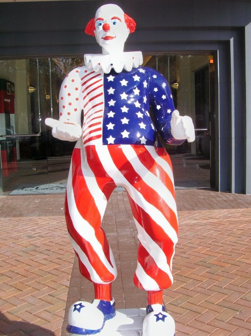 a large statue of a clown holding a usa flag