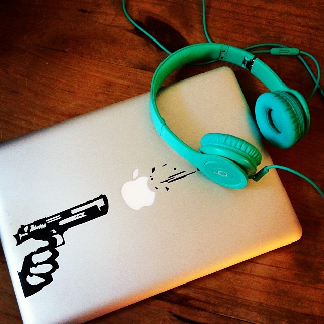 an ipod and headphones sitting on top of a laptop