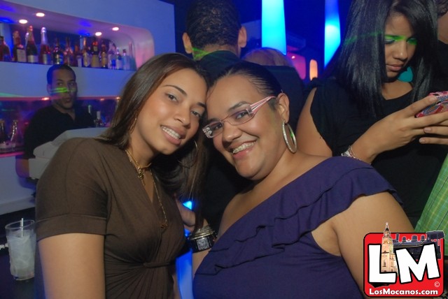 two women standing next to each other in a club