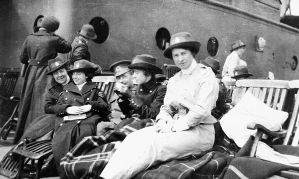 black and white pograph of four women sitting on benches