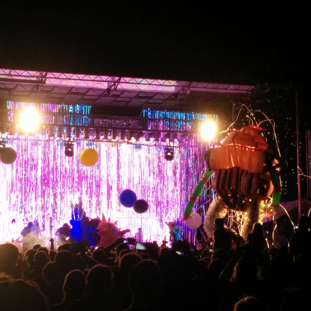 people at an outdoor stage set up with balloons