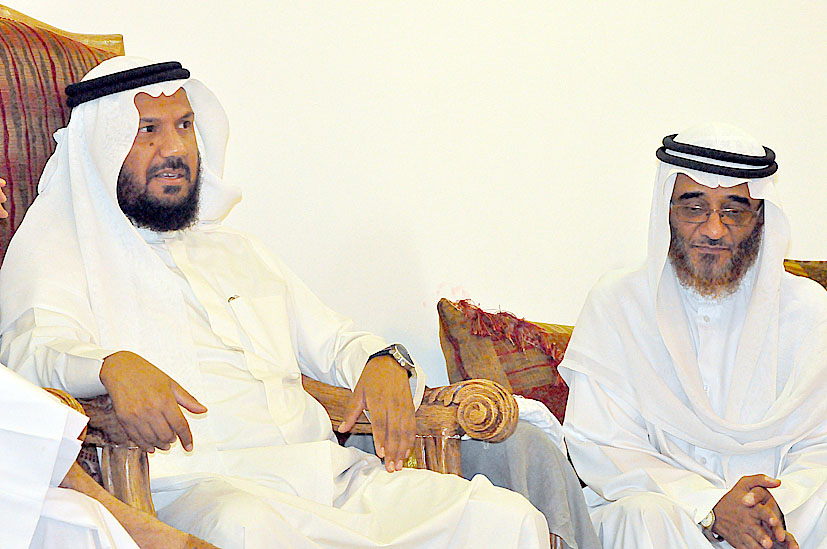 two men sit next to each other in chairs