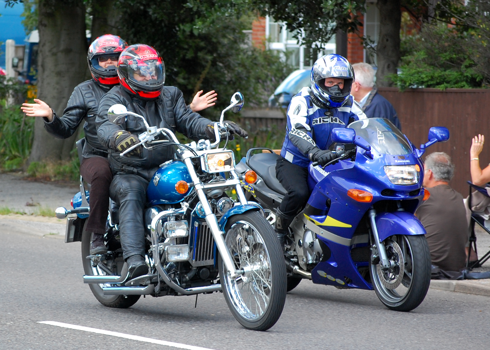 two people riding on the back of two motorcycles